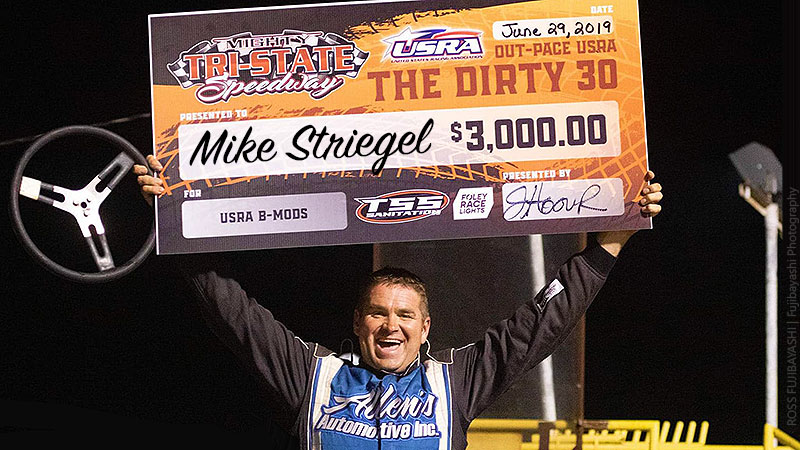 Mike Striegel celebrates after winning the Out-Pace USRA B-Mod main event during the 